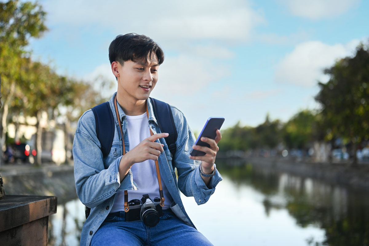 man looking at phone for help while traveling