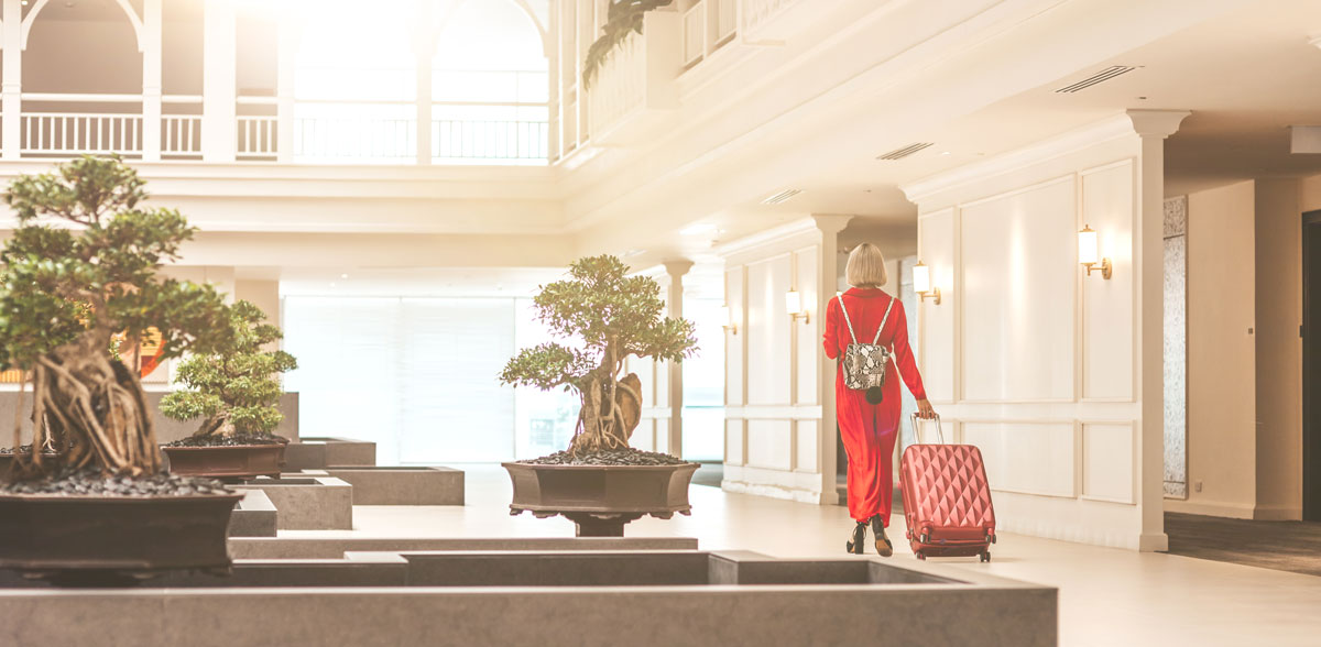 women with suitcase walking through hotel lobby