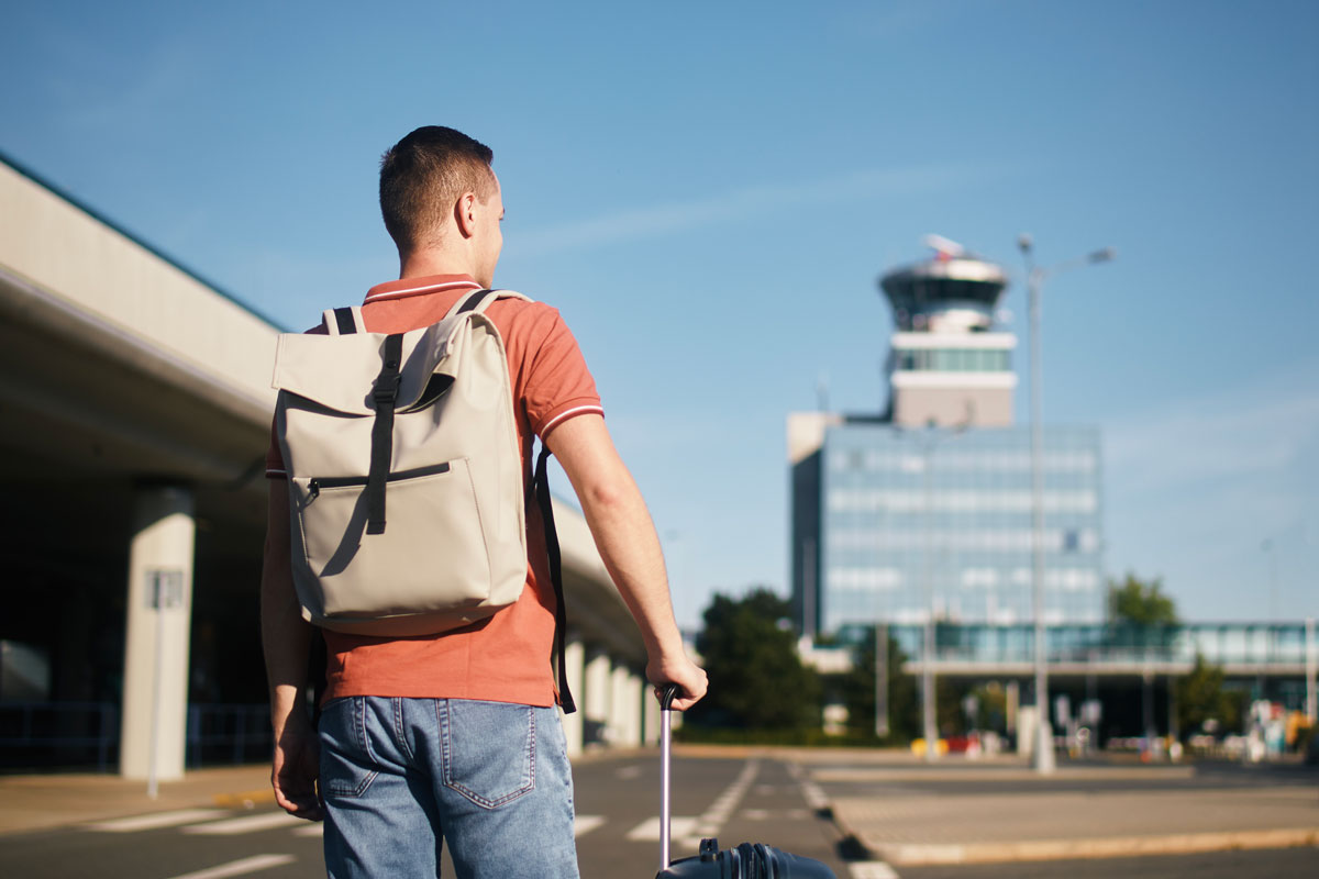 man walking outside of airport traveling